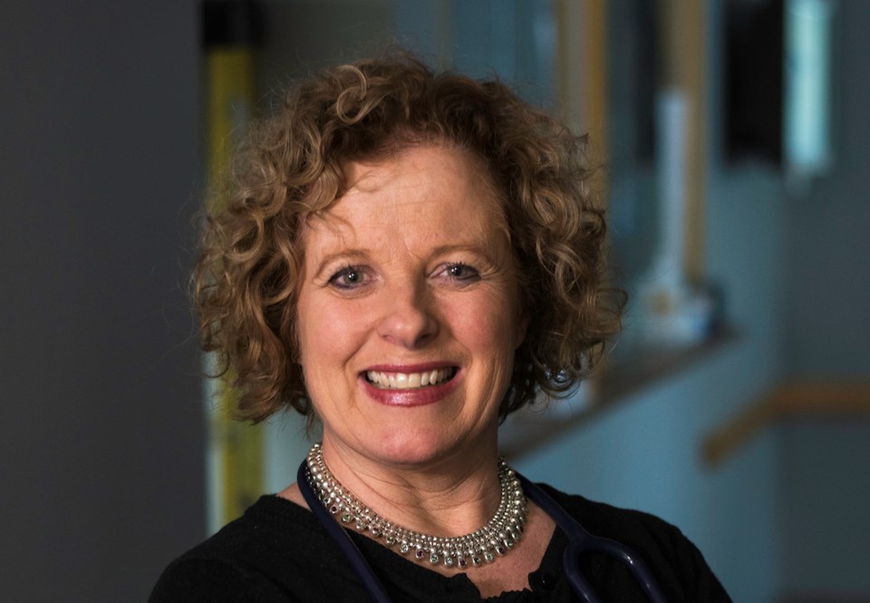 a smiling white woman with a necklace on